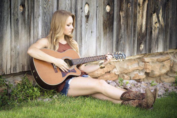 "Comment se positionner pour bien chanter?" D. WEX Music : fille assise jouant de la guitare.