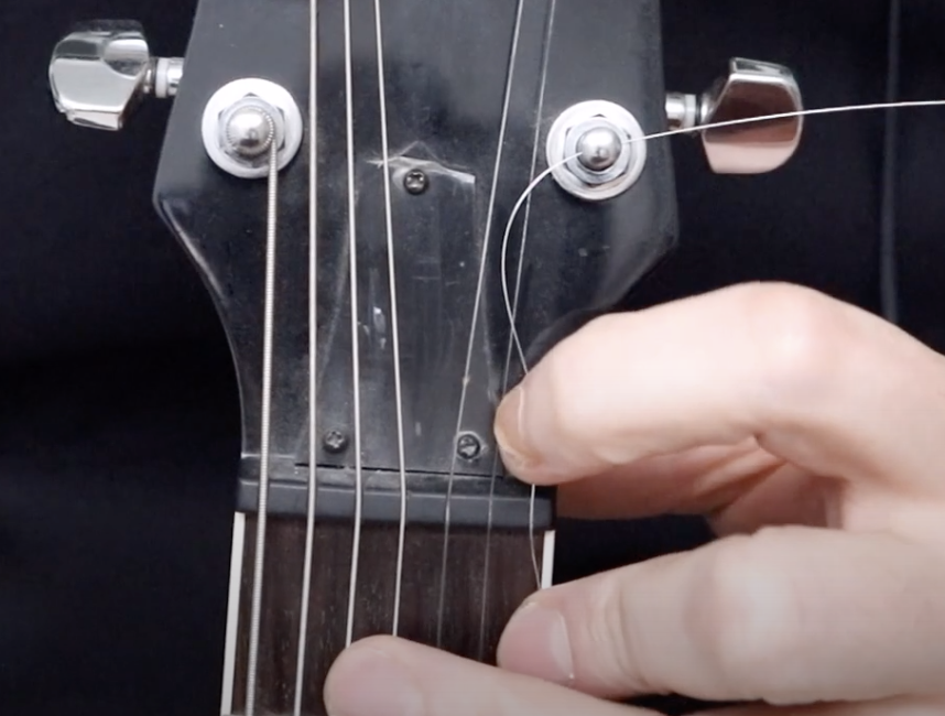 Comment changer ses cordes de guitare par D. WEX Music : placement d'une corde dans le sillet de tête